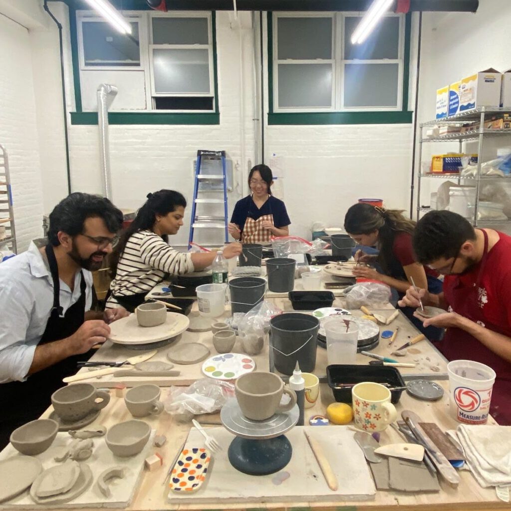 A small group of people deeply engaged with handbuilding with clay